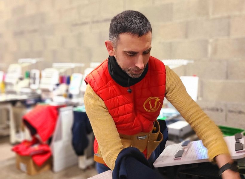 Un technicien d'Orléans Textile en pleine production de vêtements personnalisés.